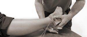 Legitimerad naprapat behandlar en stukad fot med elbehandling